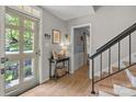 Light-filled foyer featuring hardwood floors, a stylish console table, and staircase access at 9707 Enid Ln, Matthews, NC 28105