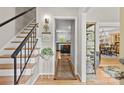 Inviting foyer with hardwood floors, stairs, and view into the kitchen and dining area at 9707 Enid Ln, Matthews, NC 28105