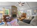 Cozy living room featuring a brick fireplace, vaulted ceilings, and natural light at 9707 Enid Ln, Matthews, NC 28105