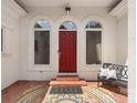 Inviting front entrance with a red door, decorative rug, and a charming bench with pillows at 1004 Berwick Ct, Waxhaw, NC 28173