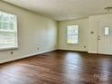 Inviting living room featuring hardwood floors, neutral paint, and plenty of natural light at 12713 Frank Wiley Ln, Charlotte, NC 28278