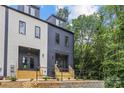 A modern townhome exterior with stylish color scheme, wooden stairs, and adjacent landscaping at 1354 Briar Creek Rd, Charlotte, NC 28205
