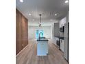 A contemporary kitchen features an island with a black countertop, white cabinets, and modern light fixtures at 1354 Briar Creek Rd, Charlotte, NC 28205
