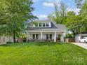 Charming home featuring a manicured lawn, a light gray roof, white trim and a welcoming front porch at 1614 Brook Rd, Charlotte, NC 28205