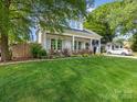 Charming home featuring a manicured lawn, a light gray roof, white trim and a welcoming front porch at 1614 Brook Rd, Charlotte, NC 28205