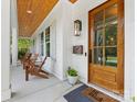 Inviting front porch with wooden ceiling, chairs and a wooden front door at 1614 Brook Rd, Charlotte, NC 28205