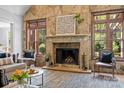 Cozy living room features a stone fireplace with mantel and large windows offering natural light at 21305 Sandy Cove Rd, Cornelius, NC 28031