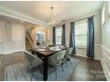 Bright dining room with modern chandelier, table setting, and large windows with natural light at 2164 Hanging Rock Rd, Fort Mill, SC 29715