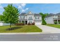 Charming two-story home features a manicured lawn and an attached two-car garage at 2164 Hanging Rock Rd, Fort Mill, SC 29715