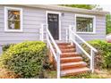 Inviting home entrance with brick steps, white railings, and a dark front door at 444 Oakwood Ave, Mooresville, NC 28115
