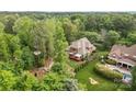 Aerial view of a stately home surrounded by lush greenery, a large deck, and manicured landscaping at 4563 Osprey Run Ct, Denver, NC 28037