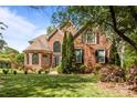 Charming brick home featuring a lush lawn, mature trees, and elegant architectural details at 4563 Osprey Run Ct, Denver, NC 28037