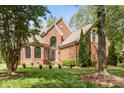 Well-maintained brick home with a lush lawn, mature trees, and classic architectural design at 4563 Osprey Run Ct, Denver, NC 28037