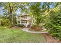Charming two-story home featuring a double porch and inviting curb appeal surrounded by mature trees at 552 Blue Rock Dr, Charlotte, NC 28213