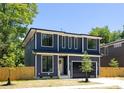 Two-story home featuring a modern design, dark gray siding, black trim windows, and a sleek, dark-colored garage door at 554 W Cama St, Charlotte, NC 28217