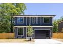 New construction two-story home featuring a modern design, black trim windows, and a sleek, dark-colored garage door at 554 W Cama St, Charlotte, NC 28217