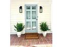 Inviting front entrance with a stylish door, brick walkway, and decorative potted plants at 611 Heathermoor Ct, Charlotte, NC 28209
