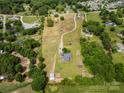 Picturesque aerial shot of a property with winding driveway and a home surrounded by verdant trees and open spaces at 6218 Indian Trail Fairview Rd, Indian Trail, NC 28079