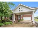Charming single-Gathering home featuring a brick facade, covered entrance with columns, and an attached garage at 6218 Indian Trail Fairview Rd, Indian Trail, NC 28079