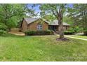 Beautiful brick home with lush green lawn and mature trees, offering a serene and private setting at 7221 Leaves Ln, Charlotte, NC 28213