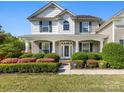 Inviting front porch with lush landscaping and a clear view of the home's architectural charm at 7325 Forrest Rader Dr, Mint Hill, NC 28227