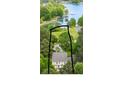 An aerial view of a house with a grey roof surrounded by trees and a lake in the background at 7525 Windy Pine Cir, Denver, NC 28037