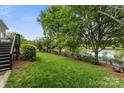 Scenic backyard with a manicured lawn, elegant fence, mature trees and a tranquil water view at 7811 Compton Ct, Charlotte, NC 28270