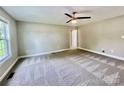 Neutral bedroom features a ceiling fan, carpet, and large window at 915 Klondale Ave, Kannapolis, NC 28081