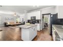Bright kitchen featuring an island with granite countertops, white cabinets and hardwood floors at 12328 Chickasaw Dr, Huntersville, NC 28078
