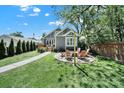 Inviting backyard features a fire pit with chairs, a lush lawn, and a charming gray home exterior at 1517 Parkwood Ave, Charlotte, NC 28205