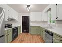 Well-lit kitchen with stainless steel appliances, wooden floors, and green-painted cabinets at 177 Candlestick Dr, Statesville, NC 28625