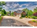 Spacious driveway leads to a brick home with an attached garage and lush landscaping at 181 Edgewater Rd, Hickory, NC 28601