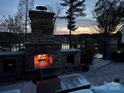 Stone outdoor fireplace on a patio overlooking the water, creating a cozy and inviting ambiance for evening gatherings at 181 Edgewater Rd, Hickory, NC 28601