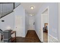 Open foyer with hardwood floors, staircase, wainscoting, and view into the bedroom at 1948 Winpole Ln, Charlotte, NC 28273