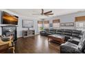 Spacious living room with hardwood floors, fireplace, large black leather sofa, and modern fan at 1948 Winpole Ln, Charlotte, NC 28273