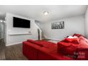 Spacious living room with hardwood floors, TV, and a comfortable red sectional sofa at 2046 E Park Dr, Lancaster, SC 29720