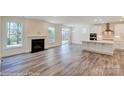 Bright living room showcasing a fireplace, luxury vinyl plank flooring, and access to the kitchen at 3242 Bozeman Ct # 8, Stanley, NC 28164