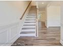 Elegant staircase with wood railing and luxury vinyl plank flooring, leading to the upper level at 3242 Bozeman Ct # 8, Stanley, NC 28164