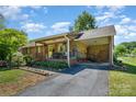 Ranch home showcasing a covered front porch, carport, and landscaped yard with mature trees on a sunny day at 3624 Delgany Dr, Charlotte, NC 28215