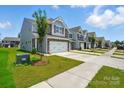 Street view of the townhomes showcasing well-maintained lawns and modern architectural design at 4254 Black Ct # 231, Harrisburg, NC 28075