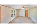 Bedroom with carpet, a ceiling fan, and a large window that provides ample natural light at 4408 Robins Nest Rd, Concord, NC 28027