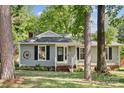 Single-story home with gray siding, black shutters, and a front yard with mature trees at 6412 Old Meadow Rd # 69, Charlotte, NC 28227