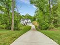 Long concrete driveway leading up to a beautiful two-story home surrounded by lush trees at 8136 Energy Ln, Catawba, NC 28609