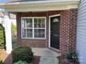 Close-up of the brick entryway featuring a stylish black door with the house number prominently displayed at 12120 Stratfield Place Cir, Pineville, NC 28134