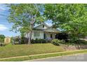 Charming single-story home with mature shade trees, a blue front door, and lush landscaping at 209 S Ransom St, Gastonia, NC 28052