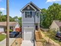 Two story home with gray vertical siding, garage, and wooden steps to the front door at 3205 Morning Dr, Charlotte, NC 28208