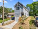 Two story home with gray vertical siding, garage, and wooden steps to the front door at 3205 Morning Dr, Charlotte, NC 28208