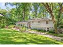 Charming two-story home with grey siding, red door, beautiful landscaping, and mature trees at 3329 Winnipeg Cir, Charlotte, NC 28210