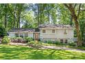 Traditional two-story home with mature trees, landscaped yard, and gray painted brick at 3329 Winnipeg Cir, Charlotte, NC 28210