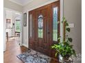 Elegant foyer featuring a decorative wood door with glass inserts, hardwood floors, and a plant accent at 3398 Millstone Creek Rd, Lancaster, SC 29720
